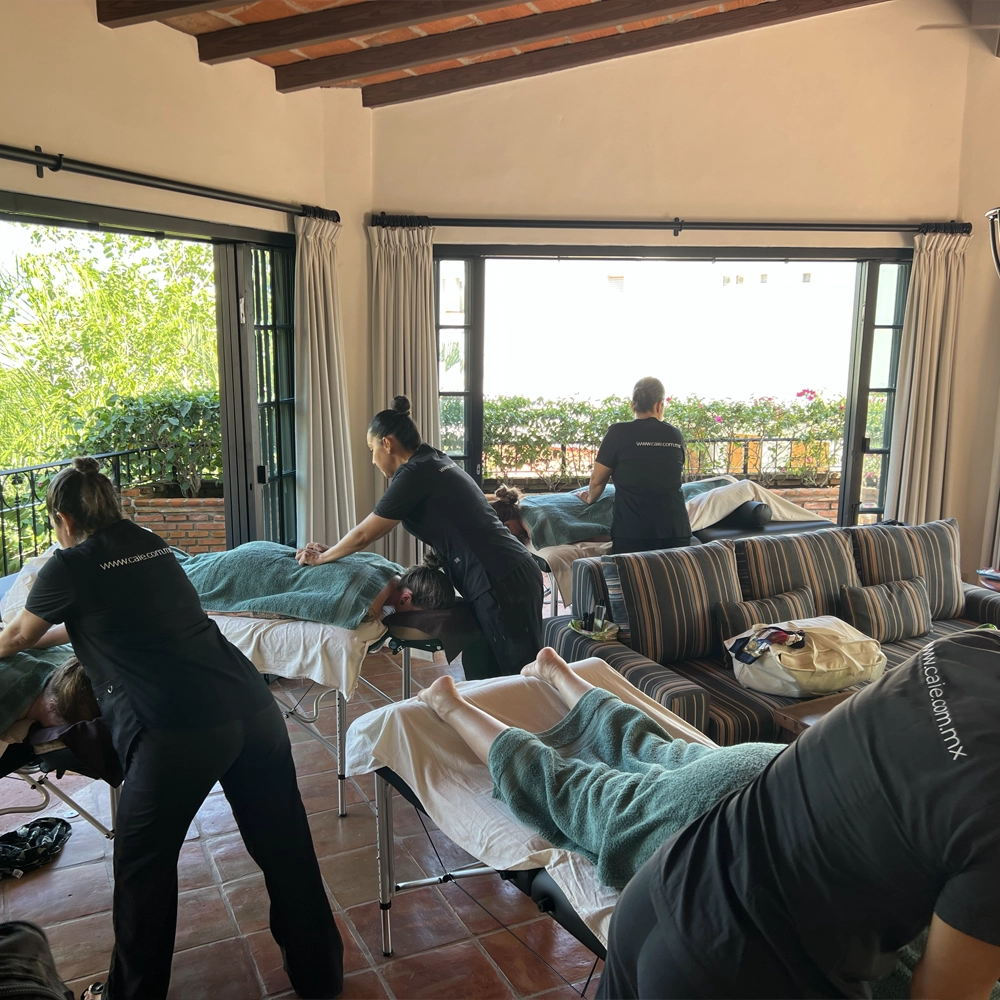 CAIE Spa therapist performing aromatherapy massage in a tropical villa.